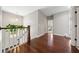 Bright hallway featuring hardwood floors, white banister, and views of bedroom and the exterior at 6090 Pennant Ln, Suwanee, GA 30024