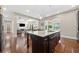 Open concept kitchen and living area featuring dark cabinets, granite countertops, hardwood floors, and modern appliances at 6090 Pennant Ln, Suwanee, GA 30024