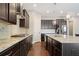Beautiful kitchen with dark cabinetry, stainless steel appliances, granite countertops, and modern lighting fixtures at 6090 Pennant Ln, Suwanee, GA 30024