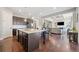 Spacious kitchen with island, dark wood cabinets, granite countertops, open to a living room with fireplace and built-ins at 6090 Pennant Ln, Suwanee, GA 30024