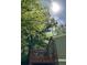 Back porch of home with outdoor seating, overhead shade from trees, and a glimpse of a partly cloudy blue sky at 921 Hemingway Rd, Stone Mountain, GA 30088