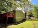 Home's backyard featuring a spacious deck perfect for outdoor enjoyment, nestled among mature trees and lush landscaping at 921 Hemingway Rd, Stone Mountain, GA 30088