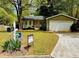 Well-maintained home featuring an inviting front yard, green siding, and a spacious two-car garage at 921 Hemingway Rd, Stone Mountain, GA 30088