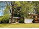 Lovely single-Gathering home boasts mature trees, green siding, and a convenient attached garage at 921 Hemingway Rd, Stone Mountain, GA 30088