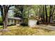 Charming home with green siding, a cozy front porch, and an attached garage surrounded by lush trees at 921 Hemingway Rd, Stone Mountain, GA 30088