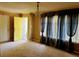 Spacious carpeted living room featuring a front door, large windows and sophisticated curtains at 921 Hemingway Rd, Stone Mountain, GA 30088