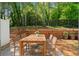 Outdoor wooden patio with table and chairs backed by a garden landscape at 1067 Brittania Rd, Stone Mountain, GA 30083