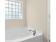 Bathroom featuring a soaking tub with tile surround and a chrome faucet at 1067 Brittania Rd, Stone Mountain, GA 30083