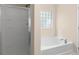 Bathroom featuring a soaking tub, glass enclosed shower and a window at 1067 Brittania Rd, Stone Mountain, GA 30083