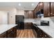 Modern kitchen with granite countertops, island, stainless steel appliances, and dark wood cabinets at 1067 Brittania Rd, Stone Mountain, GA 30083