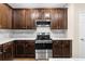 Modern kitchen with stainless steel appliances and beautiful dark wood cabinets at 1067 Brittania Rd, Stone Mountain, GA 30083