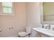 Half bathroom with a pedestal sink, toilet, mirror and neutral wall colors at 2808 White Oak Ln, Decatur, GA 30032