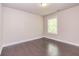 A bright bedroom features light walls, beautiful dark wood floors, and a window at 2808 White Oak Ln, Decatur, GA 30032