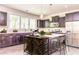 Open-concept kitchen featuring stainless appliances, island with bar seating, dark cabinetry and hardwood floors at 2808 White Oak Ln, Decatur, GA 30032