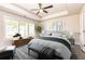Serene main bedroom with tray ceiling, a ceiling fan, large windows, and neutral decor at 2808 White Oak Ln, Decatur, GA 30032