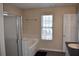 Bathroom showcasing a tub, shower with glass doors, and natural light from a window at 5229 Pinnacle Pointe Ct, Norcross, GA 30071