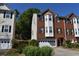 Two-story red brick townhome with a two-car garage, complemented by green shrubs at 5229 Pinnacle Pointe Ct, Norcross, GA 30071