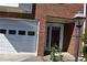 Close-up of brick front entrance, showcasing a two-car garage and a glass-paned front door at 5229 Pinnacle Pointe Ct, Norcross, GA 30071