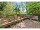 Elevated deck with wooden seating area with a view of the lush, tree-filled backyard at 1047 Winding Branch Ct, Atlanta, GA 30338