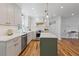 Bright kitchen boasts white cabinets, quartz countertops, stainless steel appliances, and hardwood floors at 1047 Winding Branch Ct, Atlanta, GA 30338
