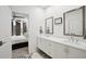 Bright bathroom with dual sinks, decorative floor tiles, and view to main bedroom at 1050 Stacks Ave # 1507, Atlanta, GA 30315