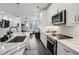 Open kitchen with stainless steel appliances, granite countertops, modern fixtures and an island bar open to the living area at 1050 Stacks Ave # 1507, Atlanta, GA 30315