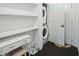 Bright laundry room features a stacked washer and dryer, shelving and cabinets at 1050 Stacks Ave # 1507, Atlanta, GA 30315