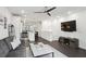 Open living room that flows into a kitchen and dining area with hardwood floors, a modern fan, and neutral decor at 1050 Stacks Ave # 1507, Atlanta, GA 30315