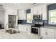 Modern kitchen with white cabinetry, stainless steel appliances, granite countertops, and a blue backsplash at 1711 Terry Mill Se Rd, Atlanta, GA 30316