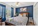 Bedroom with navy accent wall, modern ceiling fan, and large window at 2267 Howell Farms Trl, Acworth, GA 30101