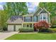 Charming two-story home featuring a lush front yard, two-car garage, and vibrant landscaping at 2267 Howell Farms Trl, Acworth, GA 30101