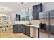 Spacious kitchen with stainless steel appliances and gray cabinets with an open view to the dining room at 2267 Howell Farms Trl, Acworth, GA 30101