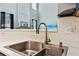 Close-up of a stainless steel kitchen sink with modern faucet and white tile backsplash at 2267 Howell Farms Trl, Acworth, GA 30101