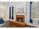 Inviting living room featuring a brick fireplace, hardwood floors, and blue patterned curtains at 2267 Howell Farms Trl, Acworth, GA 30101