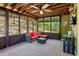 The sunroom features a brick floor, screened windows, and a red couch at 2267 Howell Farms Trl, Acworth, GA 30101