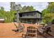 Charming backyard with Adirondack chairs arranged around a firepit and a view of the modern home at 2469 River Oak Dr, Decatur, GA 30033