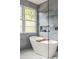Sleek bathroom with a standalone tub, unique tile work, and natural lighting at 2469 River Oak Dr, Decatur, GA 30033