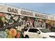 Exterior of Oak Grove Market with a large mural featuring peaches, flowers and a black background at 2469 River Oak Dr, Decatur, GA 30033