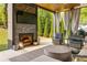 Covered patio with an outdoor fireplace, grill, and comfortable seating at 2469 River Oak Dr, Decatur, GA 30033