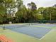 Well-maintained tennis courts surrounded by lush greenery, benches, and trees at 2469 River Oak Dr, Decatur, GA 30033