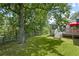 Lush backyard featuring mature trees, wooden fencing, and a deck with an umbrella-covered table at 269 Red Gate Dr, Canton, GA 30115
