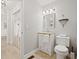 Bathroom featuring tiled floors, vanity, mirror, and a toilet, with view to hall at 269 Red Gate Dr, Canton, GA 30115