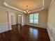 Elegant dining room featuring hardwood floors, wainscoting, tray ceiling, and chandelier at 71 Tobinleigh Ct, Acworth, GA 30101
