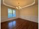 Dining room with hardwood floors, tray ceiling, chandelier, wainscoting, and a large window for natural light at 71 Tobinleigh Ct, Acworth, GA 30101