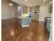 Open-concept kitchen and living area with hardwood floors, island with sink, and stainless steel appliances at 71 Tobinleigh Ct, Acworth, GA 30101