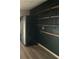 Modern kitchen features dark walls, stainless steel refrigerator, and open wooden shelving for storage and decor at 71 Tobinleigh Ct, Acworth, GA 30101