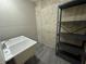 Utility sink near concrete wall with black metal shelf storage; ideal for a functional and organized space at 71 Tobinleigh Ct, Acworth, GA 30101