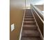 Carpeted stairway featuring a white handrail and wall, providing a safe and comfortable transition between floors at 4194 Wesley Ln, Decatur, GA 30035