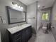 Stylish bathroom with a navy vanity, marble countertop, and a combination shower and tub, complemented by natural light at 610 Brington Close, Alpharetta, GA 30022