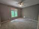 Empty bedroom featuring a neutral wall color, carpeted floors, and window overlooking trees at 610 Brington Close, Alpharetta, GA 30022